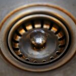 Scarico del lavandino con odore sgradevole, evidenziando la causa nascosta del problema.