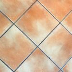 Aceto versato su fughe sporche, per un metodo efficace di pulizia e sbiancamento.